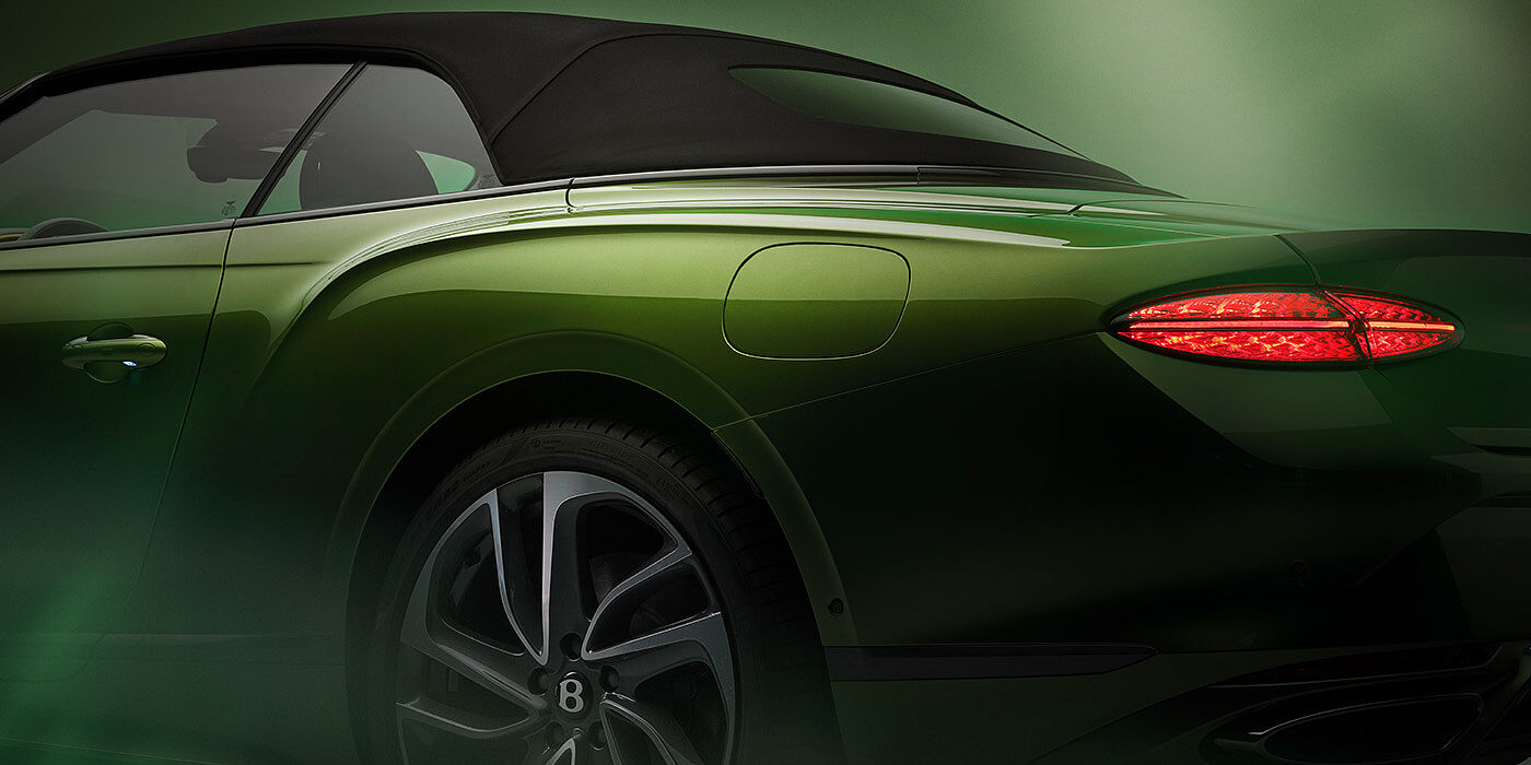 Bentley Tallinn Bentley New Continental GTC Speed rear haunch and tail lamp in Tourmaline Green paint and dark tint brightware with black hood up and illuminated head lamps